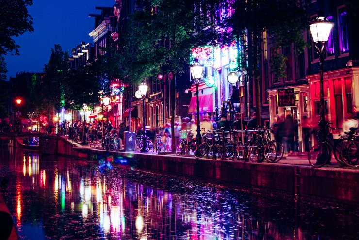 Red lights on the canals of the Amsterdam red light district by Eva Carre
